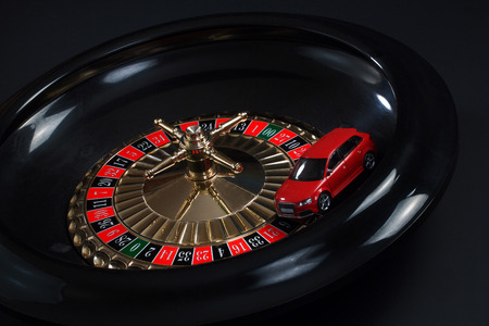 Red toy car on the roulette wheelの写真素材