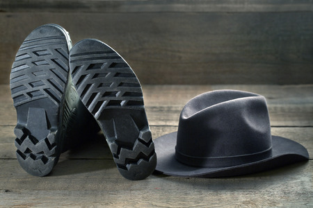 Rubber boots and felt hat on a wooden tableの写真素材