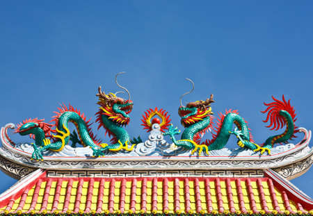Statue of twin dragons on the roof of Chinese templeの写真素材