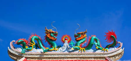 Statue of twin dragons on the roof of Chinese temple の写真素材