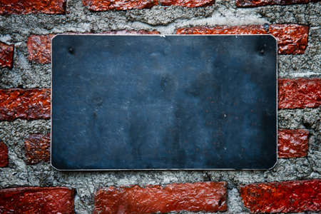 blank chalkboard hanging on brick wall  の写真素材