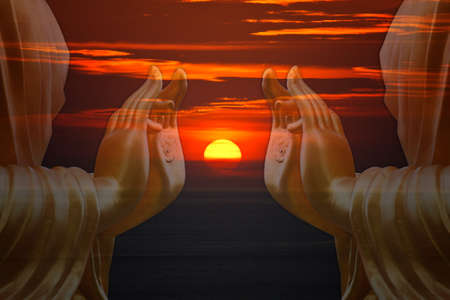hand Buddha statue with sunset sky background の写真素材