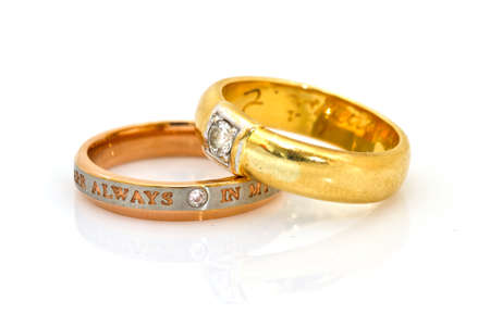Gold wedding rings engraved on white isolatedの写真素材