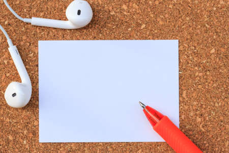 Blank paper with pen and earphone on wood tableの写真素材