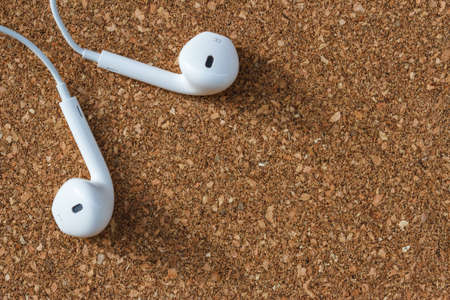 Modern portable audio earphones on wood board backgroundの写真素材