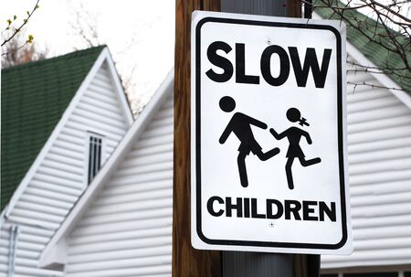 Neighborhood sign asks drivers to slow down for childrenの写真素材