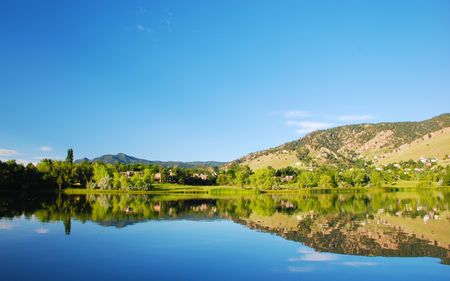 Homes line the far side of a still and serene suburban lake with lovely reflectionsの写真素材