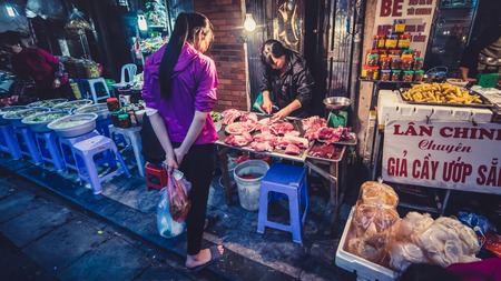 Hanoi Vietnam - November 2015: Raw meat on the Vietnamese market. Woman customers are purchasing raw meatのeditorial素材