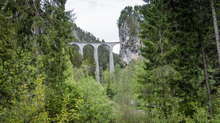 Albula - Switzerland - May 2017: Glacier train on famous landwasser Viaduct bridge.The Rhaetian Railway section from the Albula - Bernina area, Switzerland, Europe.のeditorial素材