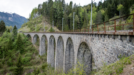 Albula - Switzerland - May 2017: Glacier train on famous landwasser Viaduct bridge.The Rhaetian Railway section from the Albula - Bernina area, Switzerland, Europe.のeditorial素材