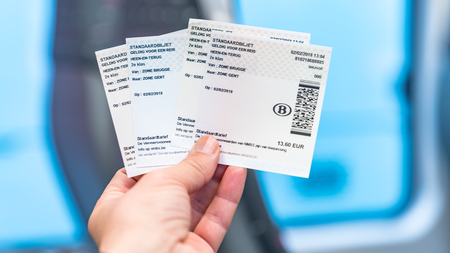 Bruges, Belgium - February 2018: Hand holding train tickets from Brugge to Ghent in Belgium