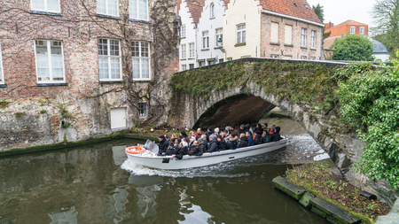 Bruges, Belgium - February 2018: Tourist sightseeing boat on canal in Bruges in winter, Bruges, Belgiumのeditorial素材