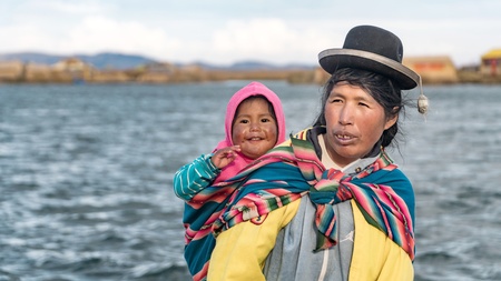Puno, Peru - September 2017: Unidentified woman and her baby at the Floating island Isla Flotante, Titicaca lake, Peruのeditorial素材