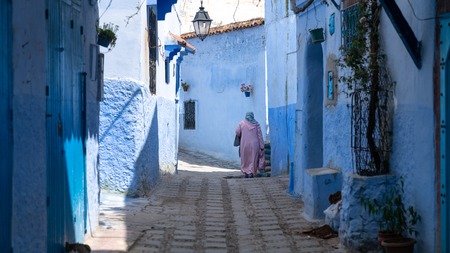 Chefchaouen , Morocco - April 2018: Unidentified woman walking in blue medina of Chefchaouen city in Morocco, North Africaのeditorial素材