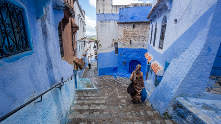 Chefchaouen , Morocco - April 2018: Unidentified woman walking in blue medina of Chefchaouen city in Morocco, North Africaのeditorial素材