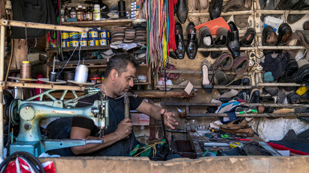 Adiyaman, Turkey - July 2018: Shaoemaker working on shoes in Adiyaman city historical old Oturakci bazaar inside the old city, Turkeyのeditorial素材