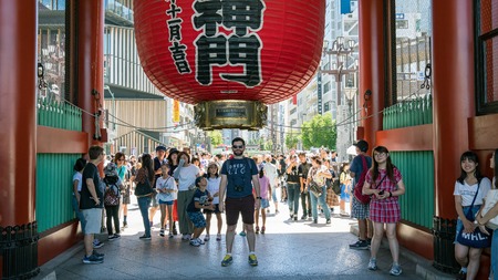 Tokyo, Japan - August 2018: Unidentified tourist posing under the big red lantern of Sensoji Asakusa temple in Tokyo, Japanのeditorial素材