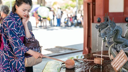 Tokyo, Japan - August 2018: Japanese woman washing hands at a dragon fountain at Sensoji Asakusa Kannon Templeのeditorial素材