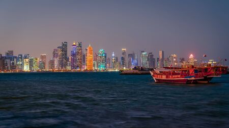 Doha, Qatar - February 2019: Doha Qatar skyline with traditional Qatari Dhow boats in the harborのeditorial素材