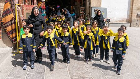 Isfahan, Iran - May 2019: A group of school kids with their teachers walking in a street in Isfahan, Iranのeditorial素材