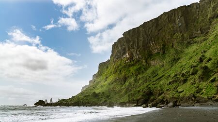 The black sand beach of Reynisfjara with rock formations in the sea, southern coast of Vik, Icelandの写真素材