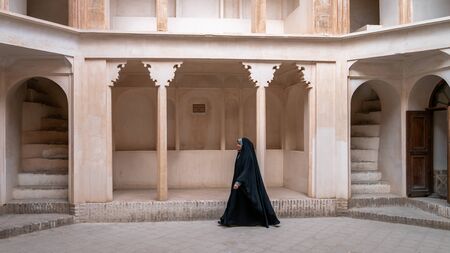Kashan, Iran - May 2019: Iranian woman in chador hijab walking inside of Tabatabaei Natanzi Khaneh Historical Houseのeditorial素材