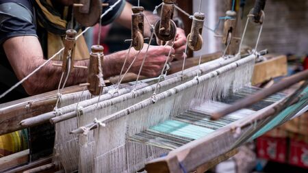 Kashan, Iran - May 2019: Iranian man crafting a wool carpet on the cotton strings in the carpet workshopのeditorial素材
