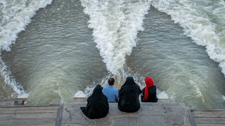 Isfahan, Iran - May 2019: Khaju bridge over Zayandeh river with tourists and local people sitting and walking aroundのeditorial素材