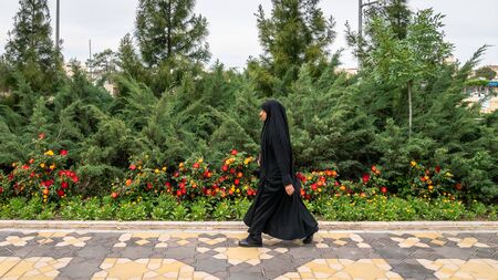Qom, Iran - May 2019: Iranian man walking a street in Qom, which is considered by Shia Muslims to be the second most sacred city in Iran.のeditorial素材