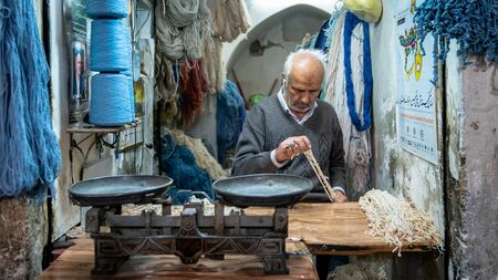 Isfahan, Iran - May 2019: Iranian man selling strings and ropes in in his shop in Grand Bazaar of Isfahanのeditorial素材