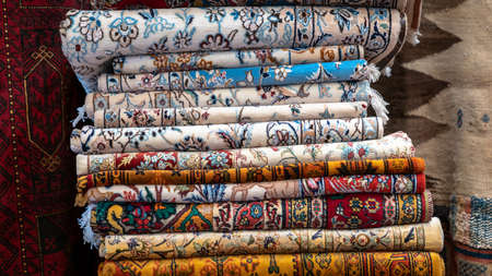 Isfahan, Iran - May 2019: Pile of traditional Iranian carpet and rugs in a carpet shop