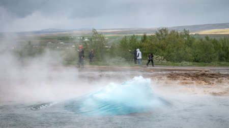 Strokkur, Iceland - May 2019: Strokkur geyser erupts while tourists are wondering in the geothermal area, Icelandのeditorial素材