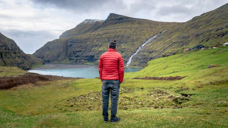 Unidentified man looking at Saksun village landscape in Faroe Islands, Denmarkのeditorial素材