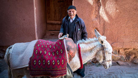 Abyaneh, Iran - May 2019: Old man and his donkey in the traditional village of Abyaneh
