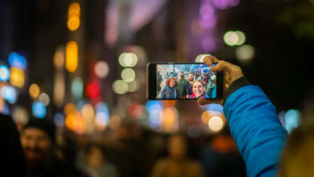 Istanbul, Turkey - November 2019: Group selfie of tourists enjoying crowded Istiklal Street in...