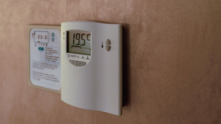 Digital Thermostat on the wall. Adjusting and setting thermostat to save energyの写真素材