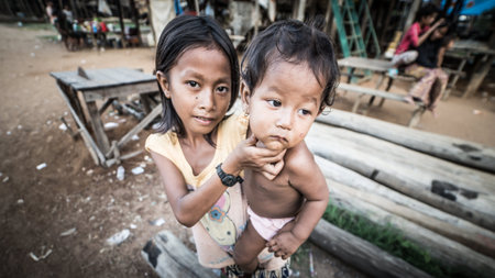 Tonle Sap Lake, Cambodia - December 2015: Young girl and his small brother at floating village of Komprongpok at Tonle Sap lakeのeditorial素材
