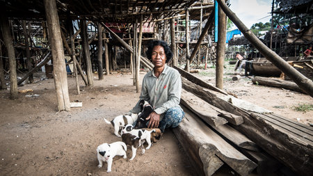 Tonle Sap Lake, Cambodia - December 2015: Woman with dog puppies at floating village of Komprongpok at Tonle Sap lake in Cambodiaのeditorial素材