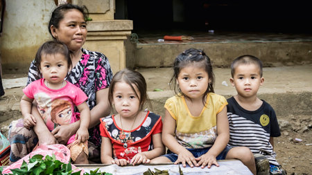 Laos - December 2015: Laos woman at a local bazaar with her childrenのeditorial素材