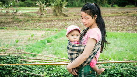 Laos - December 2015: Laos woman at a local bazaar with her babyのeditorial素材