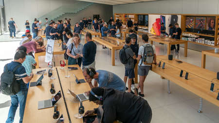San Francisco, California, USA - August 2019: People examining Apple products laptops phones and...