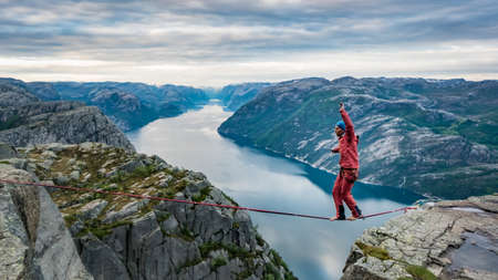Pulpit Rock, Norway - May 2016: Beautiful Norway landscape with a man walking over the rope at Preikestolen, dangerous extreme sports conceptのeditorial素材