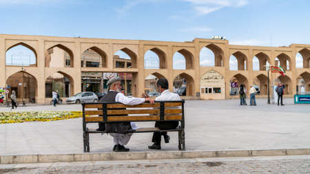 Yazd, Iran - May 2019: Iranian men sitting at a bench