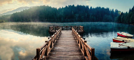 Wooden pier in Savsat Karagol Black lake in Eastern Black Sea region with morning evaporation. Savsat Karagol lake is a large trout lake in the forest in Artvin, Turkeyの写真素材