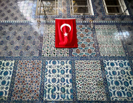 Istanbul, Turkey - November 2021: iznik tiles in Eyup Sultan mosque walls with a Turkish flag. Eyup...