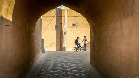 Yazd, Iran - May 2019: Kids riding a bicycle in a narrow street of old city Yazdのeditorial素材