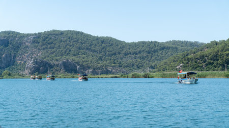 Dalyan, Ortaca, Mugla, Turkey - June 2022: Tour boats carrying tourists in Dalyan river, passing by ancient Lycian rock tombs, the stunning Iztuzu beach, and the famous mud baths.のeditorial素材
