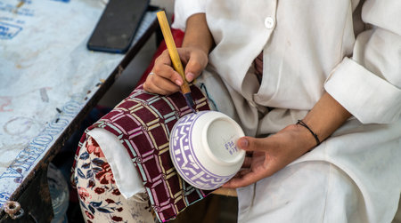 Fes, Morocco - 10 September 2022: Craftsman painting and decorating colorful ceramic products in pottery factoryのeditorial素材