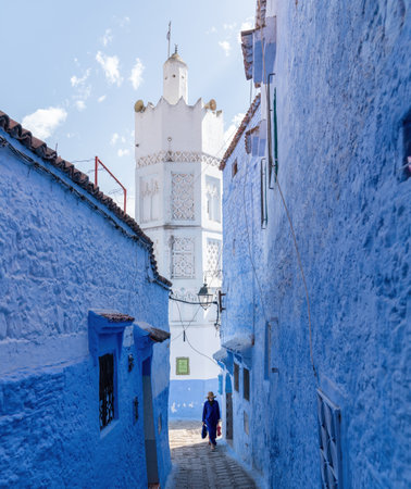 Chefchaouen, Morocco - 11 September 2022: Woman walking in Chefchaouen, known as the blue city, famous for its striking blue color painted medina buildings and streetsのeditorial素材