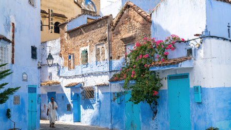 Chefchaouen, Morocco - 11 September 2022: Man walking in Chefchaouen, known as the blue city, famous for its striking blue color painted medina buildings and streetsのeditorial素材